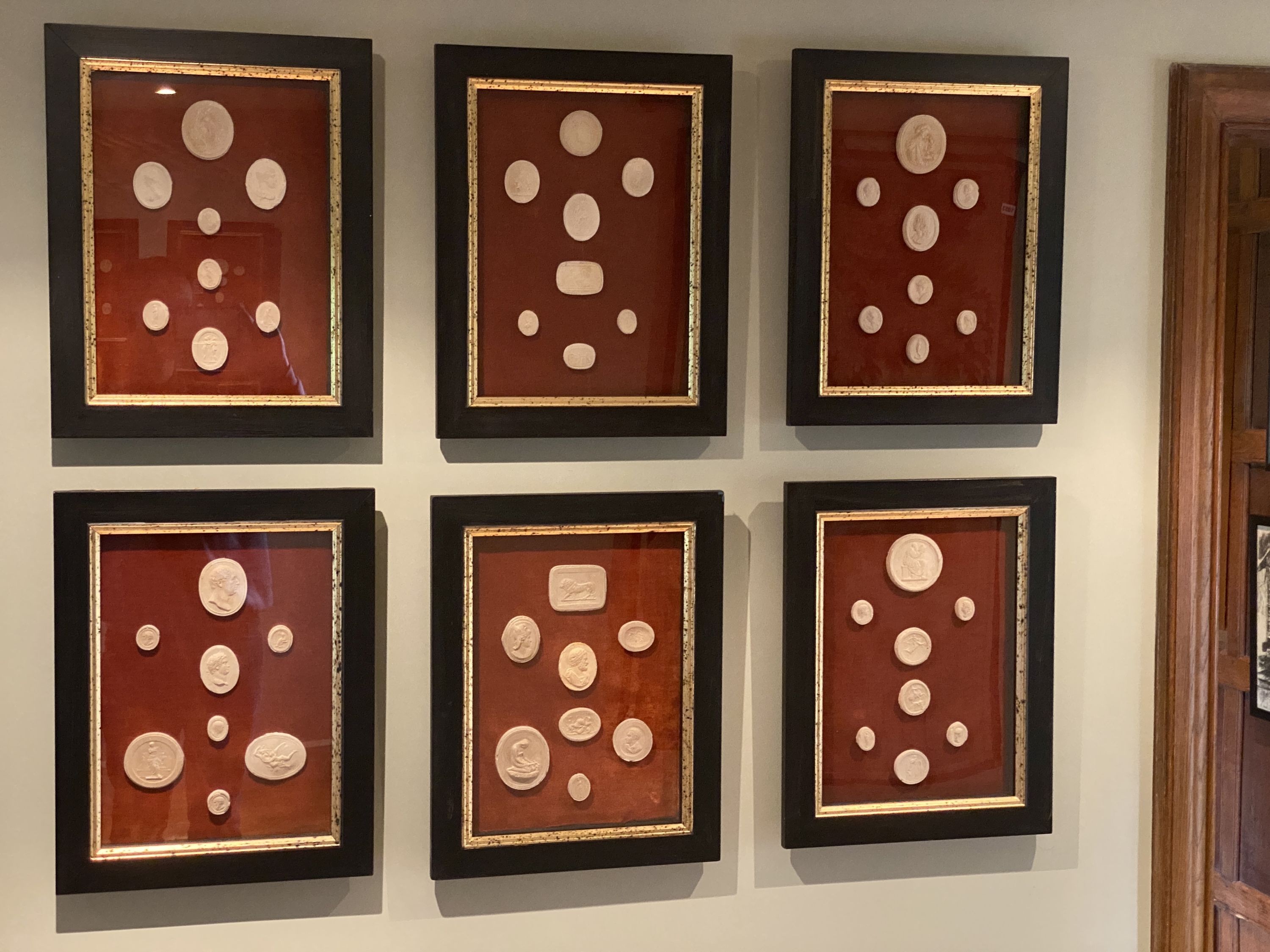 A collection of thirty four framed reproduction plaster intaglios, on velvet backing with parcel gilt ebonised frames, overall 45 x 35cm